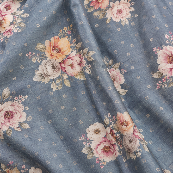Close-up of the grey-blue pure Tussar silk saree body with floral prints in blush, peach, and cream
