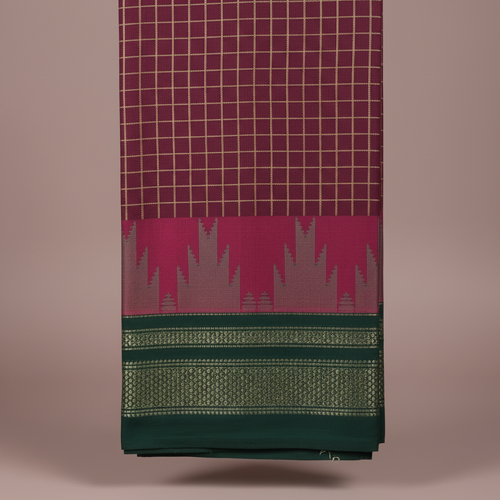 Close-up of the burgundy checked saree with its magenta jagged motif band and deep forest-green border with intricate gold-green woven detailing