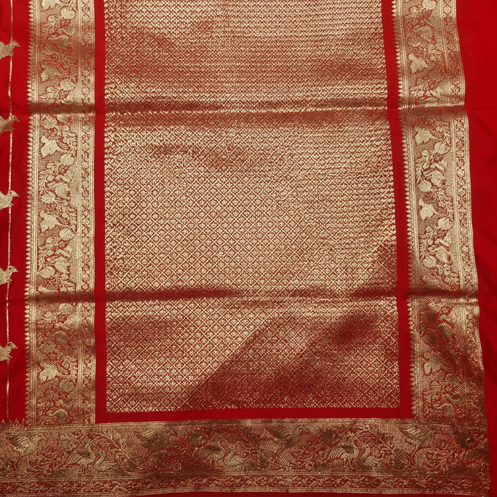 Close-up of gold-toned lattice pallu with decorative borders on red semi Banarasi saree