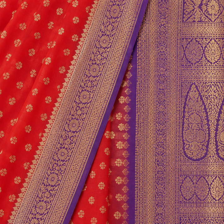 Close-up of the red saree's purple woven zari border and purple patterned pallu with gold motifs