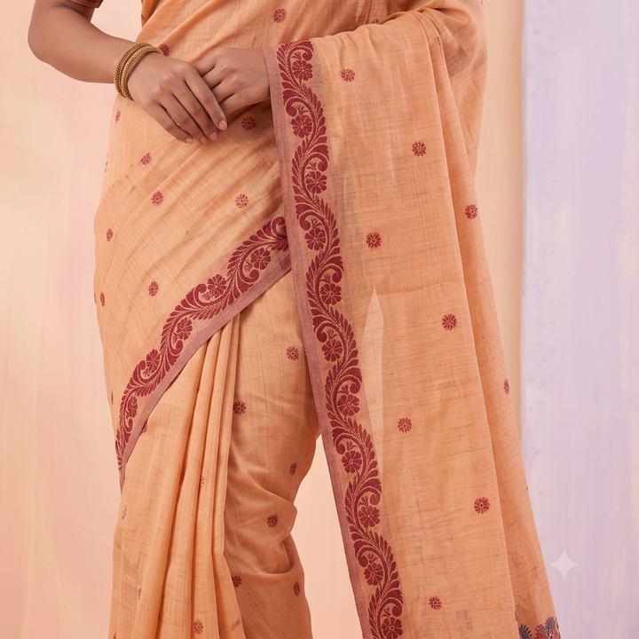 Peach saree body with scattered maroon motifs and scrolling maroon floral border