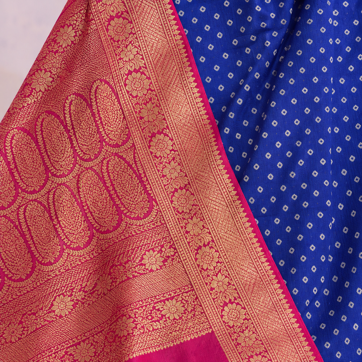 Close-up of the pink woven zari border and patterned pallu with gold motifs