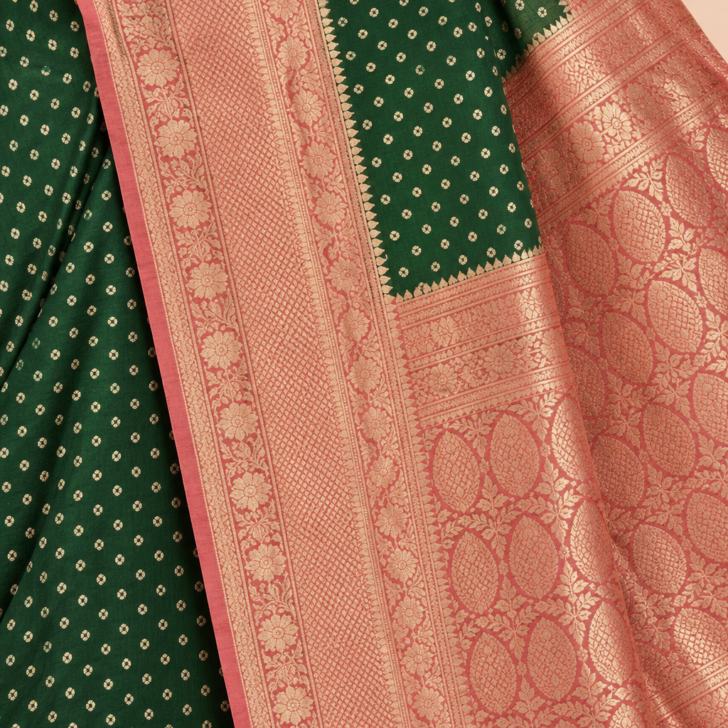 Close-up of the green saree's rose-gold woven zari border and rose-pink patterned pallu