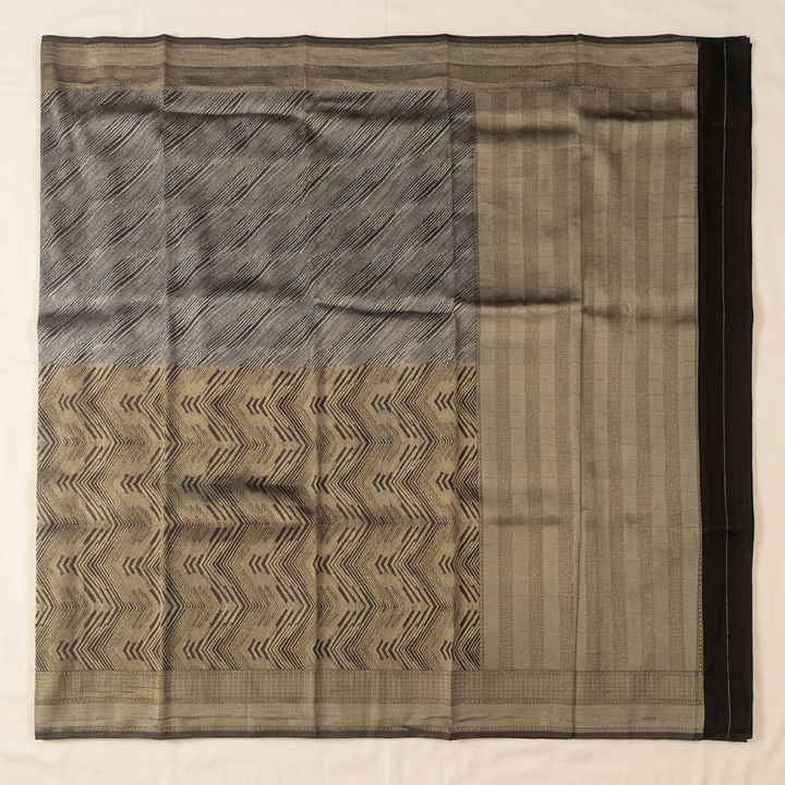Straight overhead view of black semi-Banarasi saree with gold-toned chevrons and broad pallu