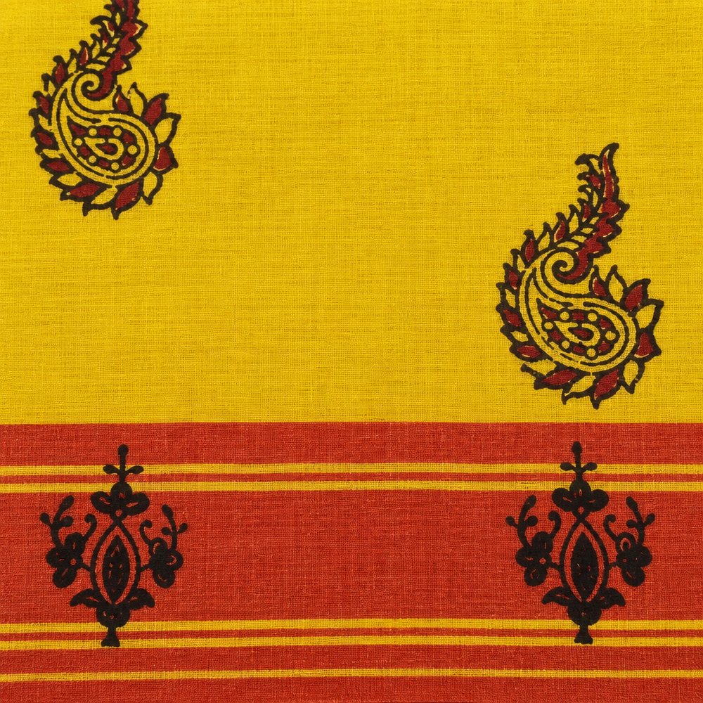 Close-up of rust-red striped border with black floral motifs on yellow saree