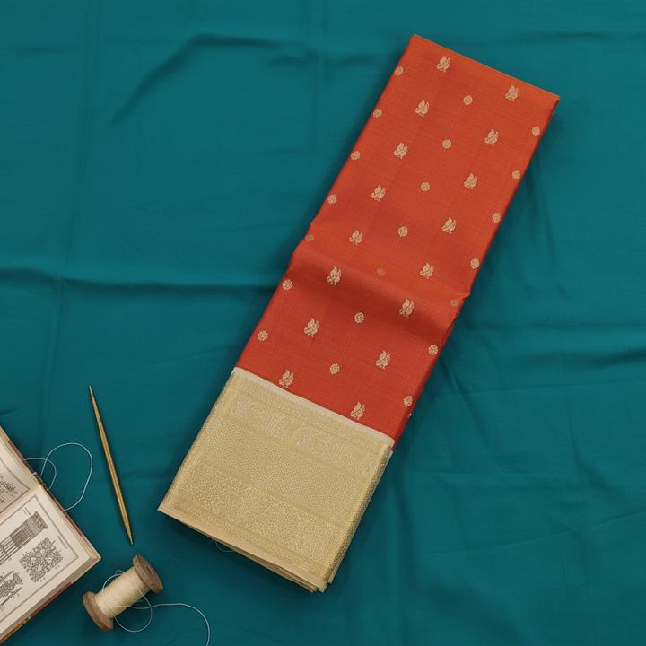 Kuberan Kanchipuram Silk Saree Orange with Scattered Gold Zari Peacock & Floral Medallion Buttas & Broad Antique Gold Zari Geometric Multi-Band Border